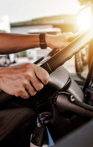 convoyeur conduisant un camion avec les deux mains sur le volant