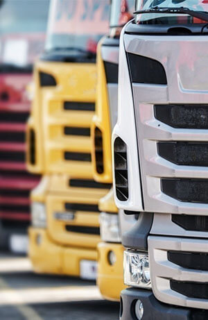 plusieurs camions de couleur différentes stationnés sur parking